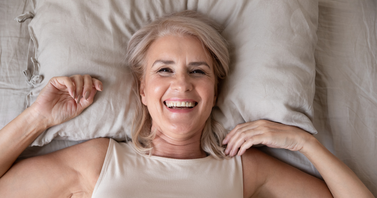 mujer adulta feliz cama